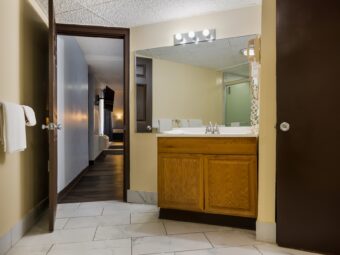 Doorway to corridor, vanity unit, mirror, towel rail with towels