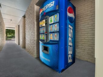 Pepsi vending machine with sodas in covered walkway