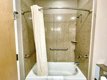 Shower tub with shower curtain and bath mat, grab bars