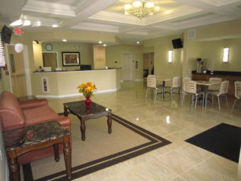 Sofa, side tables, coffee table, rug, guest check in desk, tables and chairs, tiled flooring