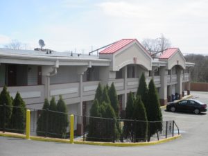 Two story building, small trees, parking spaces