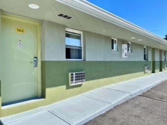 One story building with exterior room entrances, walkway and parking spaces