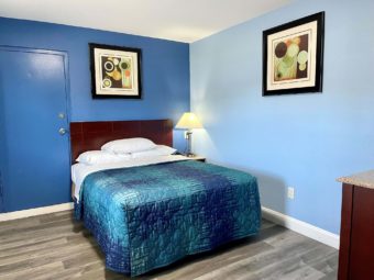 Queen bed, art images, night stand with bedside lamp, laminate flooring