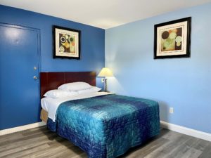 Queen bed, art images, night stand with bedside lamp, laminate flooring