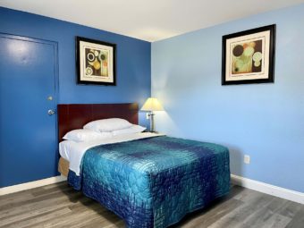 Queen bed, art images, night stand with bedside lamp, laminate flooring