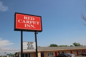 Hotel brand signage, one story building , parking spaces