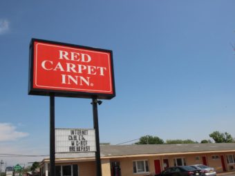 Hotel brand signage, one story building , parking spaces