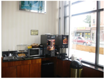 Breakfast counter display with juice and coffee machines, microwave, breakfast pastries display case
