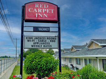 Brand signage, landscaping with flowers and shrubs, one story building