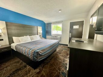 King bed, night stands with telephone, bedside wall lights, mirror, wooden drawer unit, wall mounted TV, carpet flooring
