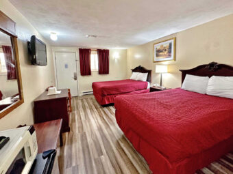 Two double beds, night stand with bedside lamp and telephone, fridge with microwave, luggage stand, mirror, wooden drawer unit, wall mounted TV, laminate flooring