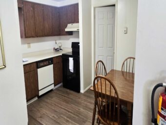 Kitchen area with dishwasher, coffee maker, stove, table and chairs, laminate flooring