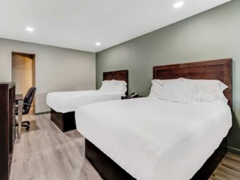 Two double beds, night stand with telephone, desk with chair, wooden unit, laminate flooring