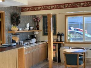 Breakfast counter displau, coffee pots, table with chairs, tiled flooring