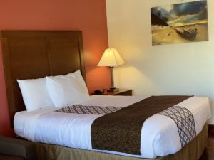 Queen bed, night stand with bedside lamp and clock