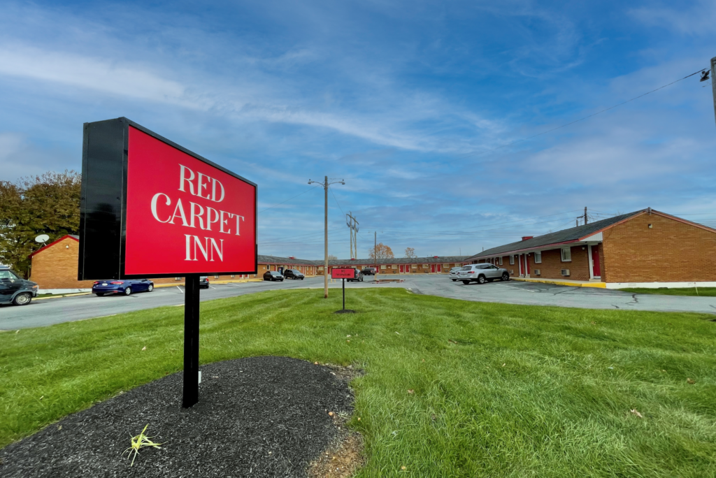 Single story building, grassy area, brand signage