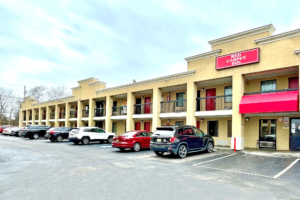 Hotel entrance, two story building with exterior room entrances, covered walkways, parking spaces