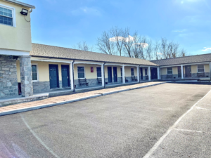 Exterior room entrances with covered walkways and wooden benches outside rooms