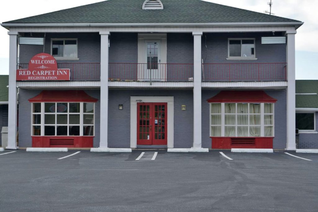 Hotel entrance, two story building, parking spaces