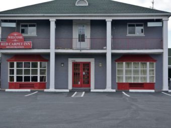 Hotel entrance, two story building, parking spaces