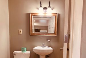 Mirror with overhead lights, sink, toilet
