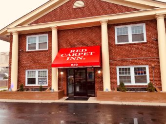 Hotel entrance, canopied entrance with brand signage, small shrubs