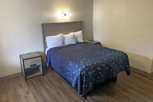 Queen bed, wall light, night stands with telephone, laminate flooring