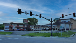 Two story building with exterior room entrances, walkways and stairs, guest parking with canopies