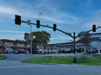 Two story building with exterior room entrances, walkways and stairs, guest parking with canopies