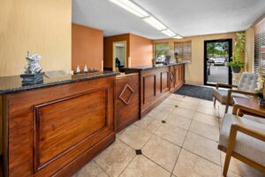 Lobby with guest check in desk, guest information leaflet stand, easy chairs, tiled flooring