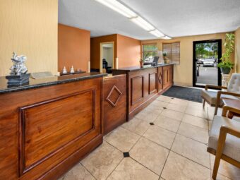 Lobby with guest check in desk, guest information leaflet stand, easy chairs, tiled flooring