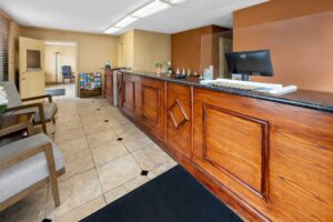 Lobby with guest check in desk, guest information leaflet stand, easy chairs, tiled flooring