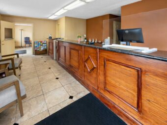 Lobby with guest check in desk, guest information leaflet stand, easy chairs, tiled flooring