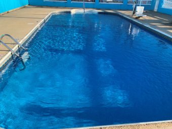 Outside pool, concrete ppolside with ADA pool chair