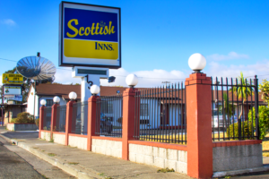 Brand signage, one story building behind fencing