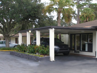Hotel entrance with drive through canopy, trees and planted areas