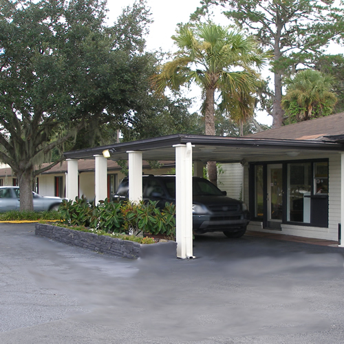 Hotel entrance with drive through canopy, trees and planted areas