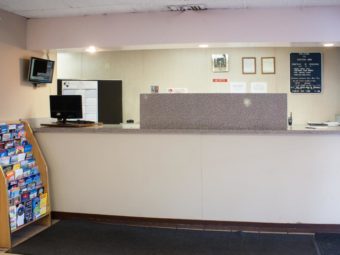 Guest check in desk, guest information leaflet stand, carpet flooring