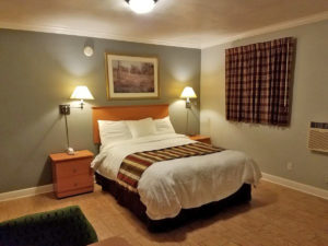 Double bed, night stands with telephone, wall mounted bedside lights and art, laminate flooring