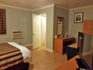 Double bed, flat screen tv, desk with ice bucket, wall mounted mirror and art, laminate flooring