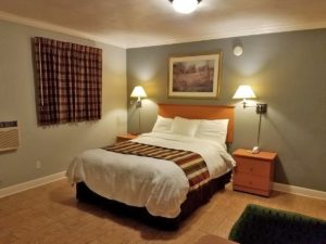 Queen bed, night stands with telephone, wall mounted lamps and art, laminate flooring