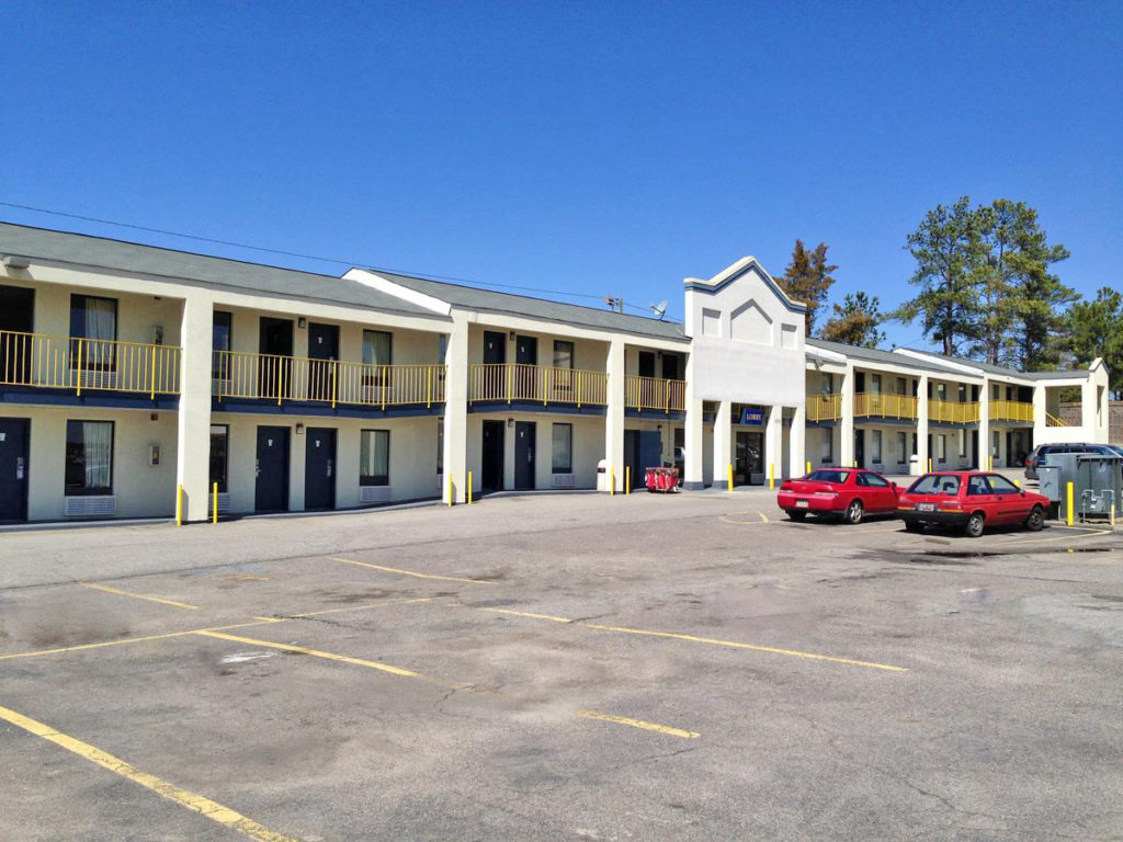 SGAAG Exterior 100 Two story building with exterior room entrances walkways and stairs, parking spaces