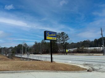 Brand Signage, grassy area, road leading to hotel entrance