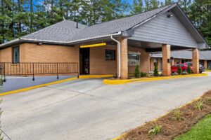 Drive through entrance canopy, landscaping with small shrubs and trees