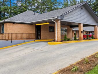 Drive through entrance canopy, landscaping with small shrubs and trees