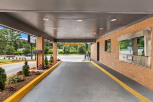 Drive through entrance canopy, landscaping with small shrubs and trees