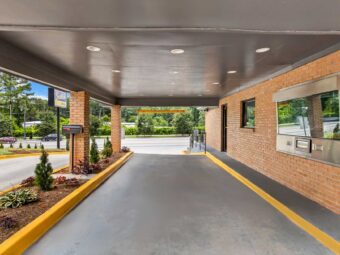 Drive through entrance canopy, landscaping with small shrubs and trees