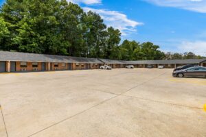 One story building with exterior guest room entrances and covered walkway, parking spaces