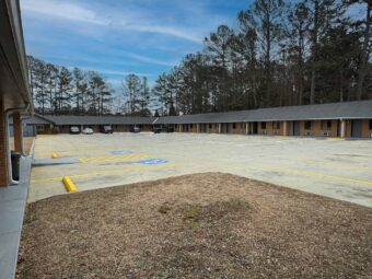 one story building with exterior guest room entrances and covered walkways, guest parking spaces outside room
