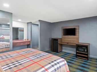 King bed, tiled mirror, vanity unit, mirror, wooden unit with fridge, TV and microwave, carpet flooring